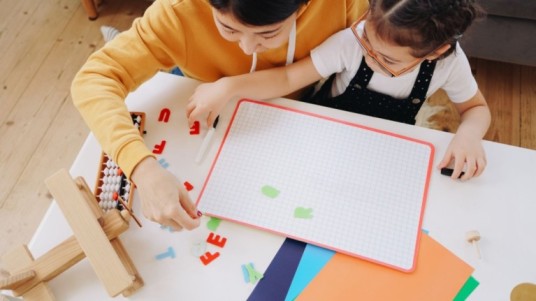 image of a teacher teaching a student on cardboard